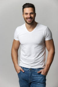 Handsome young man,boy,posing in white t shirt and jeans with hands in pockets
